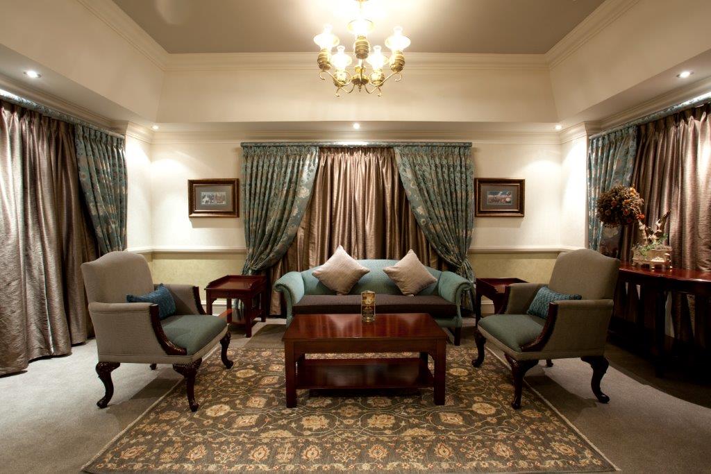 Presidential Suite lounge with twin armchairs, sofa and chandelier at Walmont Hotel at Graceland, Secunda